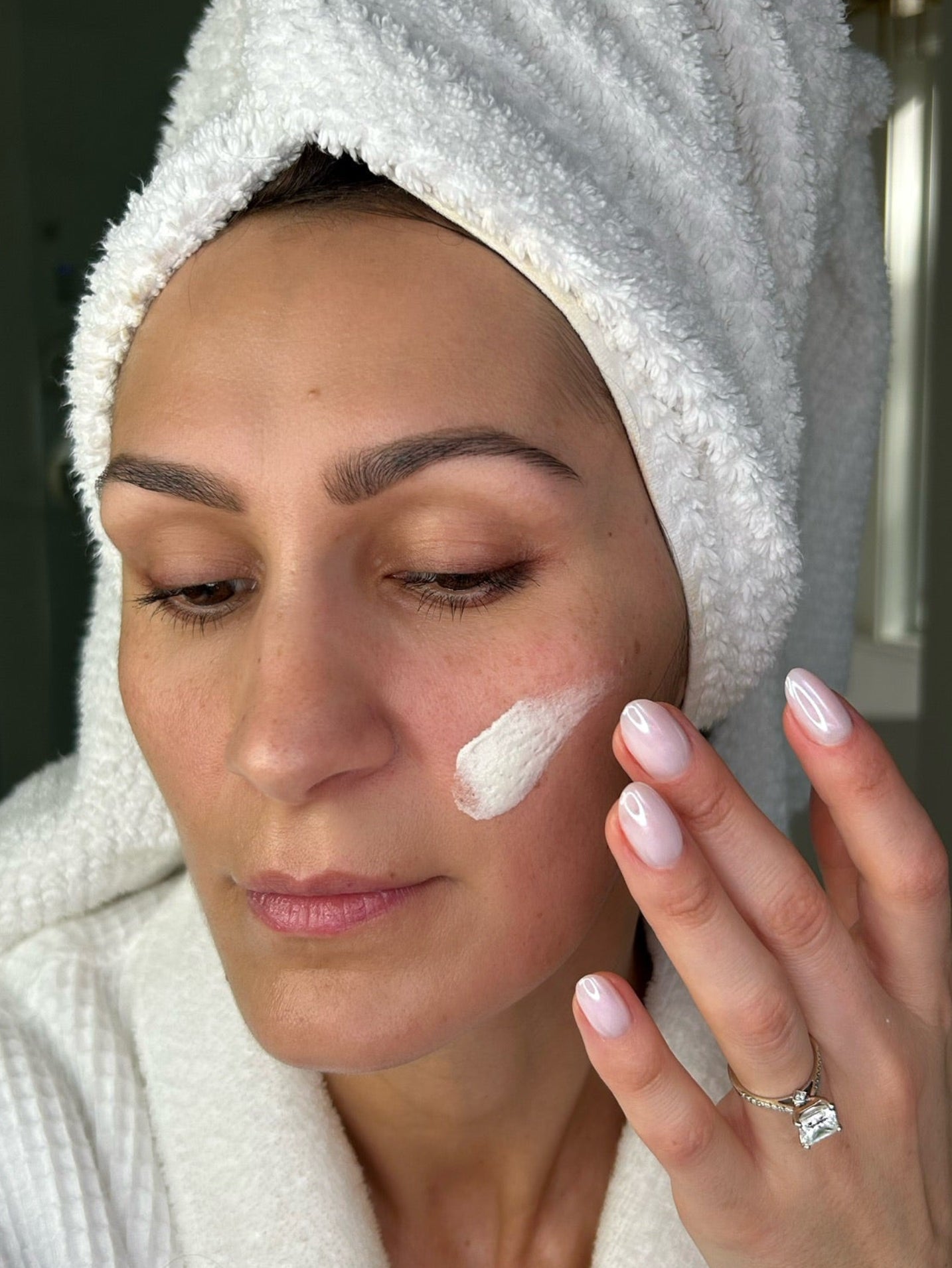 Woman rubbing texas gold tallow whipped fluff grass fed and grass finished beef tallow on face