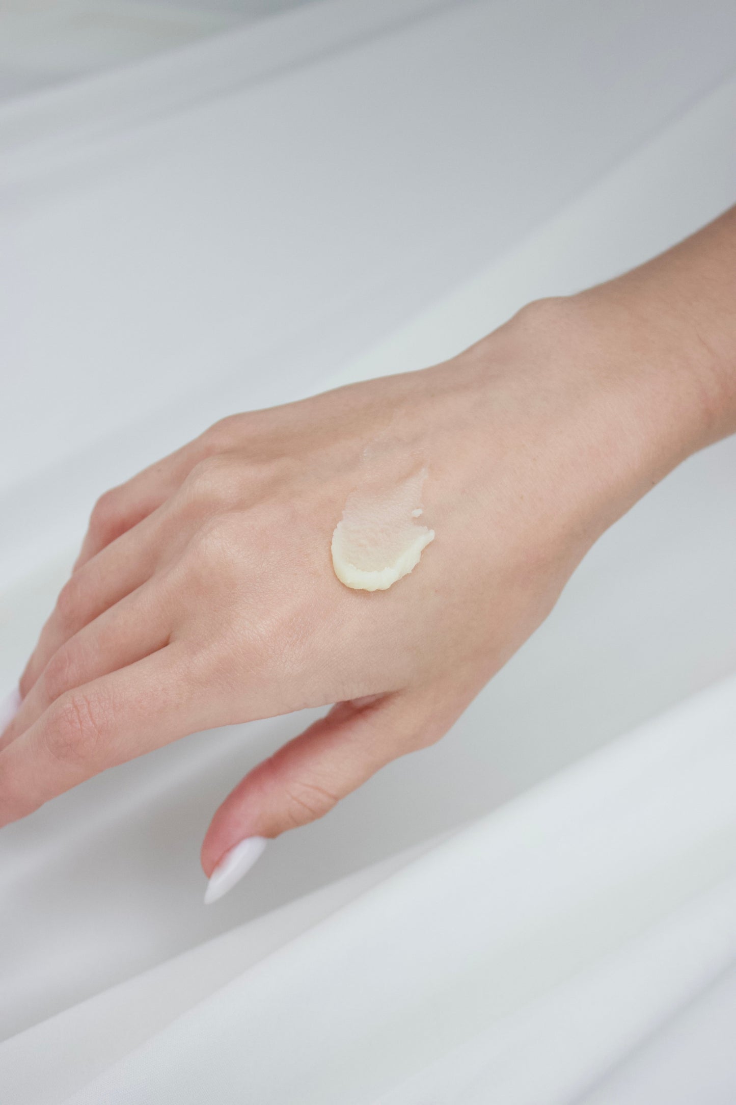 Swatch of beef tallow on a hand with a white background