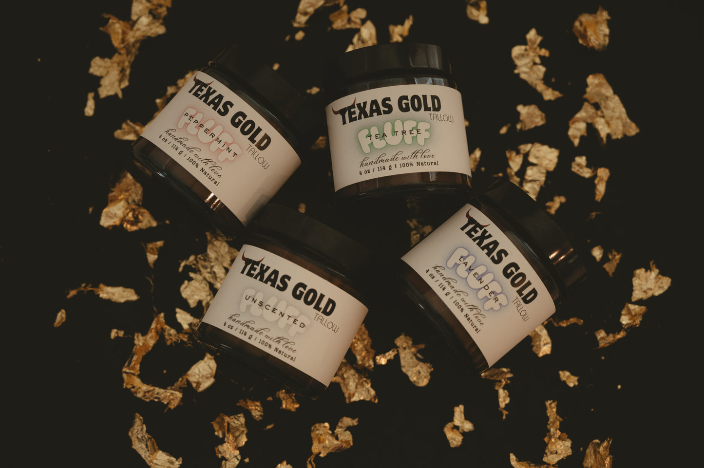 Texas Gold Tallow FLUFF tea tree, lavender, peppermint, and unscented laying on a black background with gold flakes