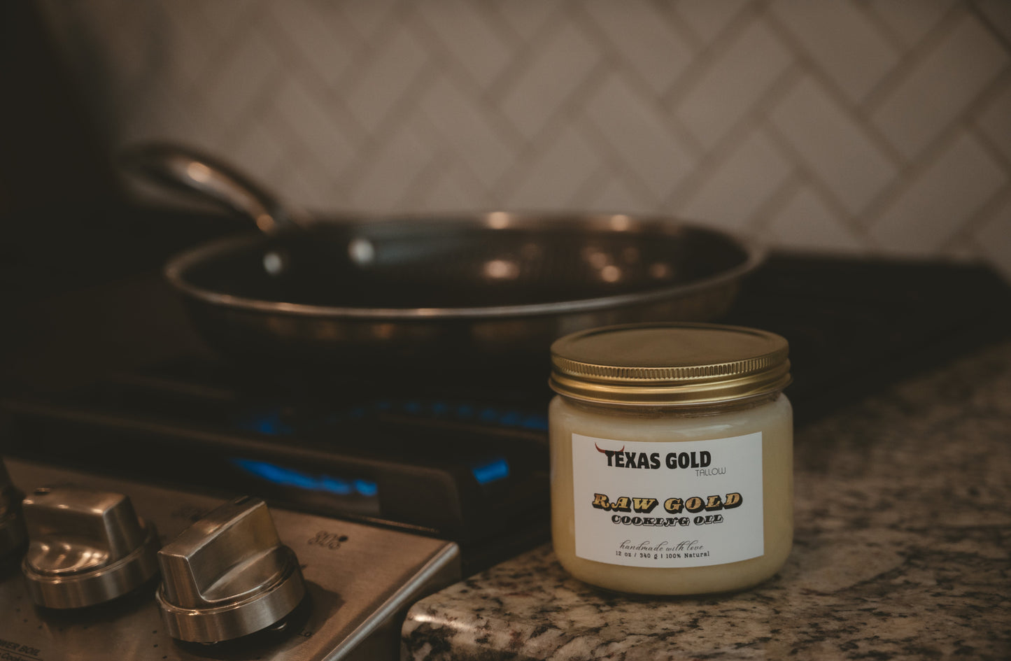 Texas Gold Tallow Raw Gold Cooking oil next to a gas stove with a HexClad pan