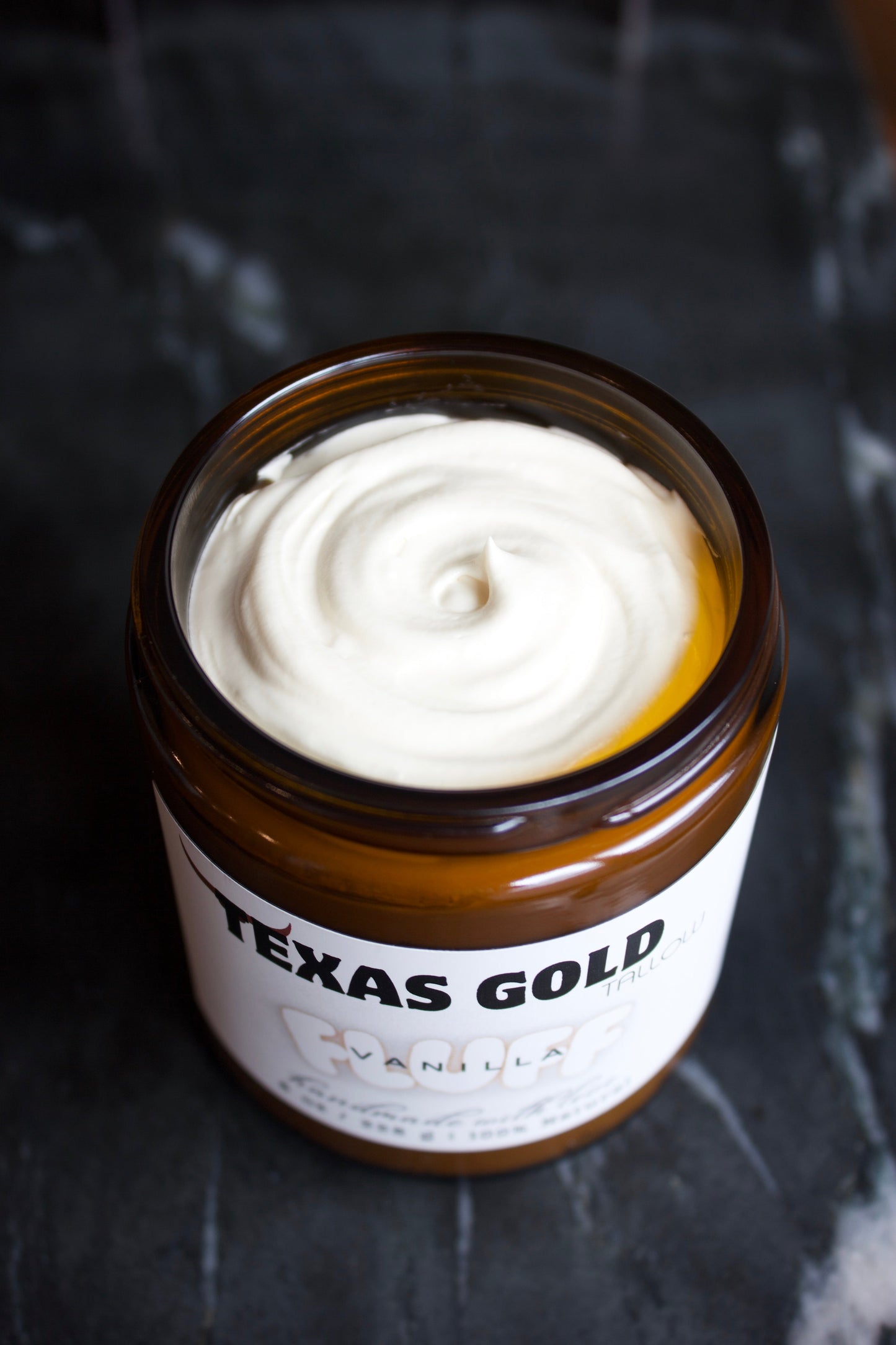 Texas Gold Tallow Vanilla FLUFF Whipped Tallow showing texture in a open jar with a black marble background