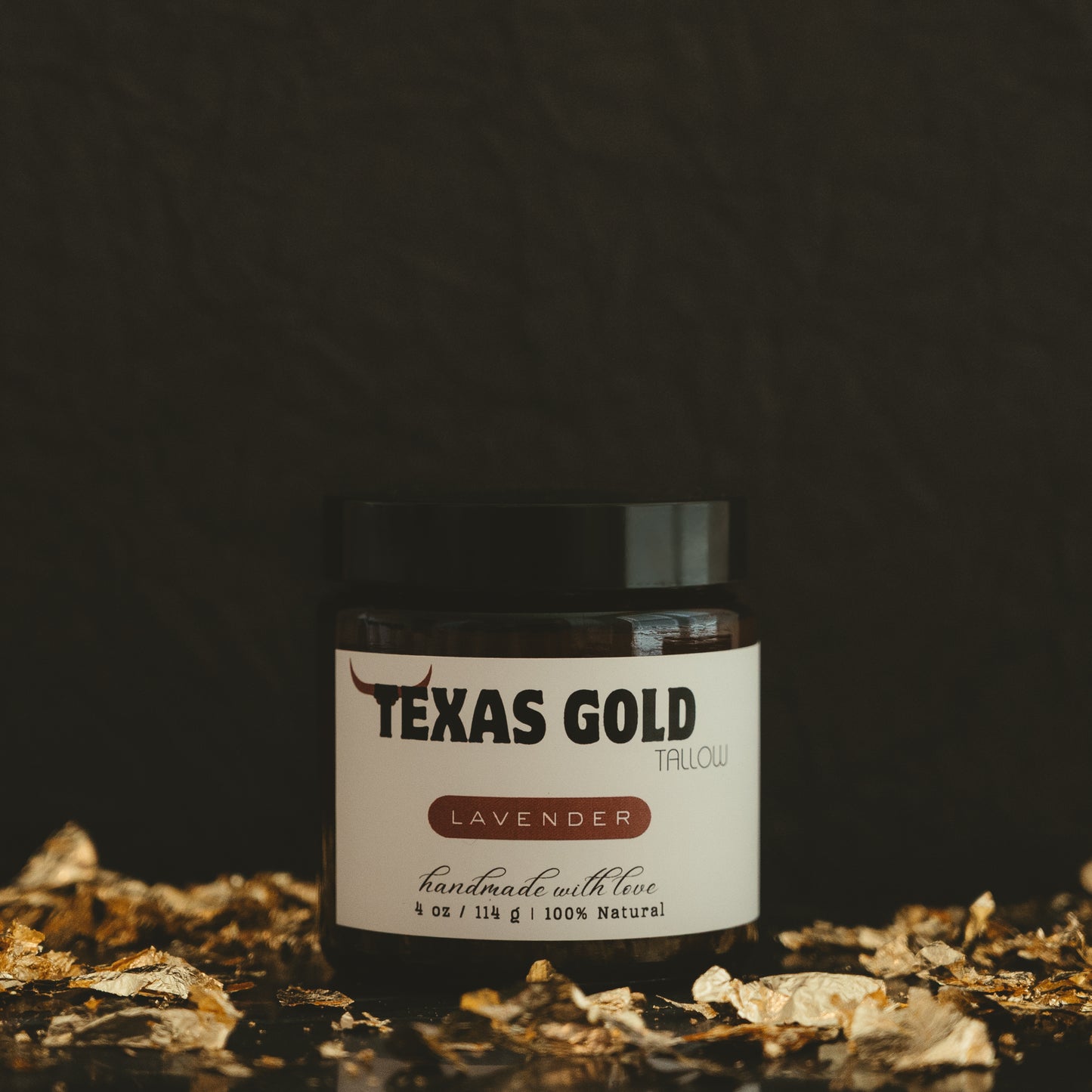 Texas gold tallow lavender balm inside a 4 ounce glass jar with black background and gold flakes