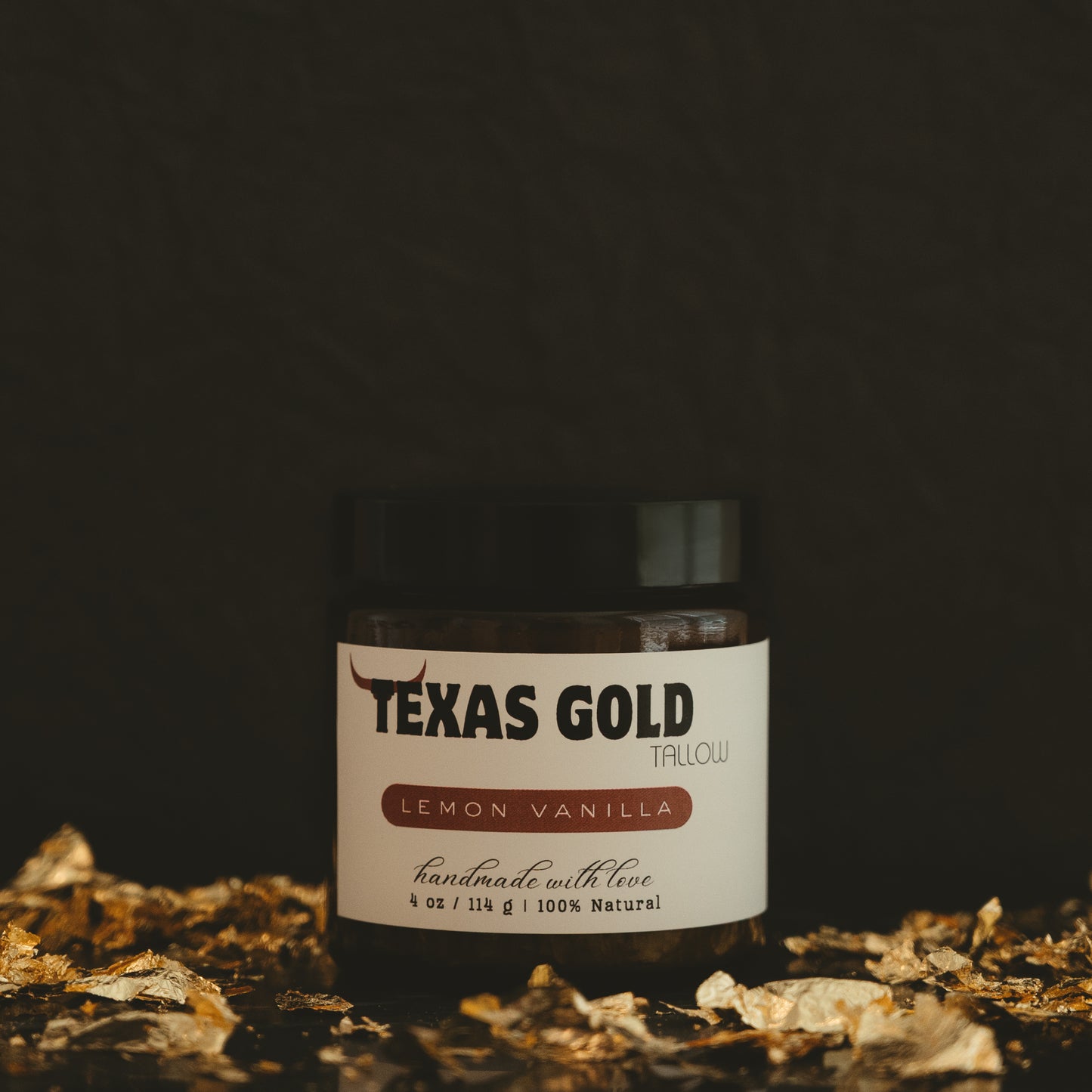 Texas gold tallow lemon vanilla balm in a 4 ounce glass jar with black background and gold flakes