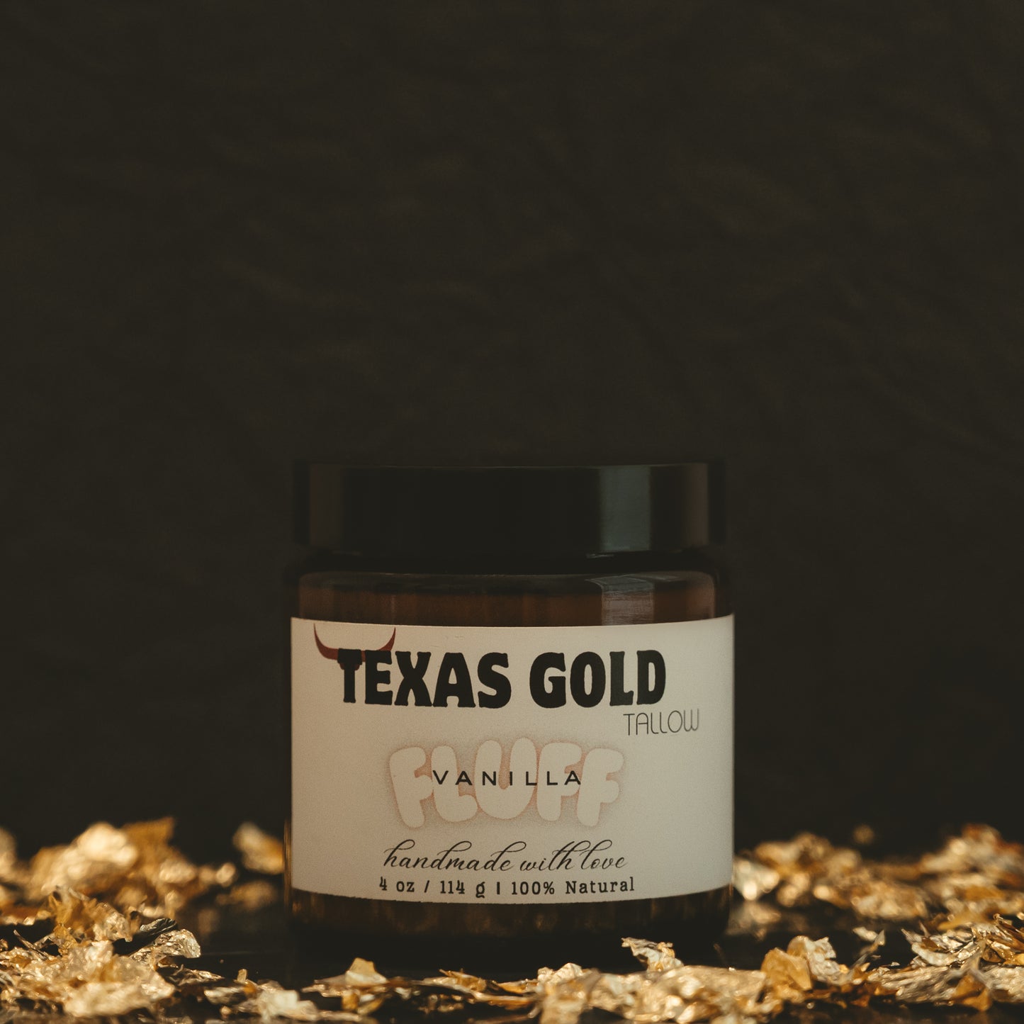 Texas gold tallow vanilla fluff, a whipped tallow inside a 4 ounce glass jar with black background and gold flakes